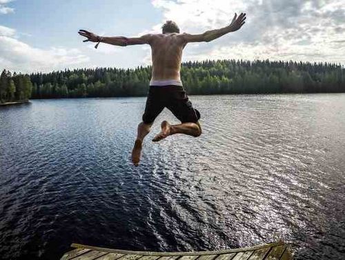 Mann springt in einen See