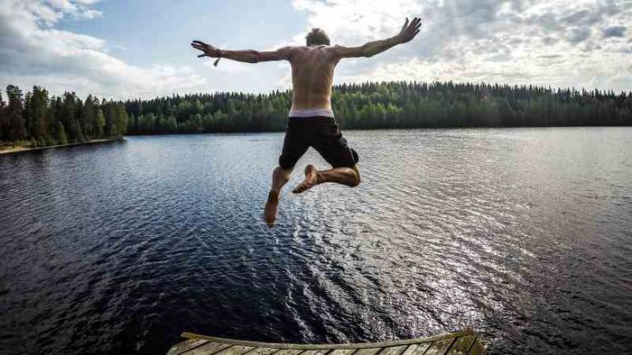 Mann springt in einen See