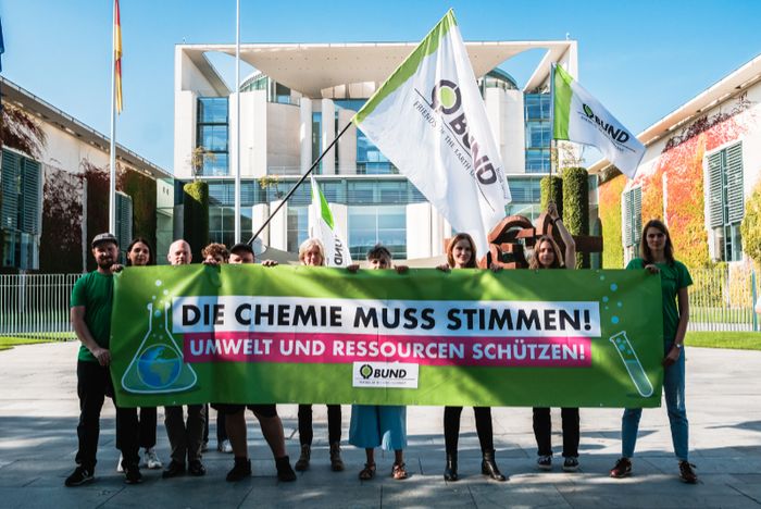 BUND-Mitarbeiter*innen stehen vorm Kanzleramt mit dem Banner "Die Chemie muss stimmen."