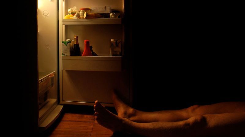 Mann liegt vor geöffnetem Kühlschrank; Foto: kallejipp / photocase.de