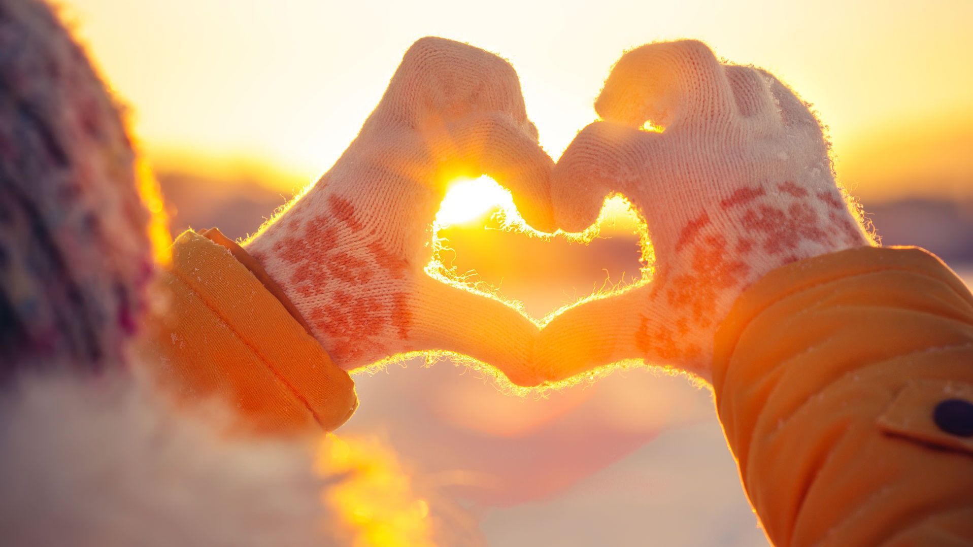 Hände zu Herz geformt vor Winterkulisse. Foto: everst / Shutterstock.com