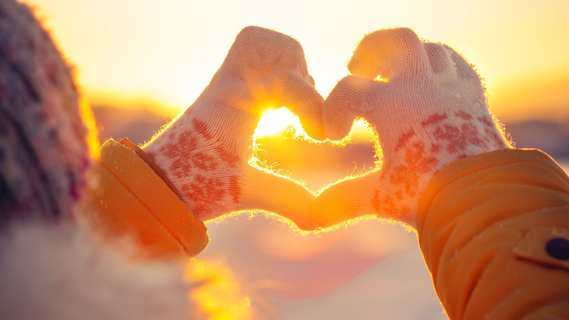 Hände zu Herz geformt vor Winterkulisse. Foto: everst / Shutterstock.com