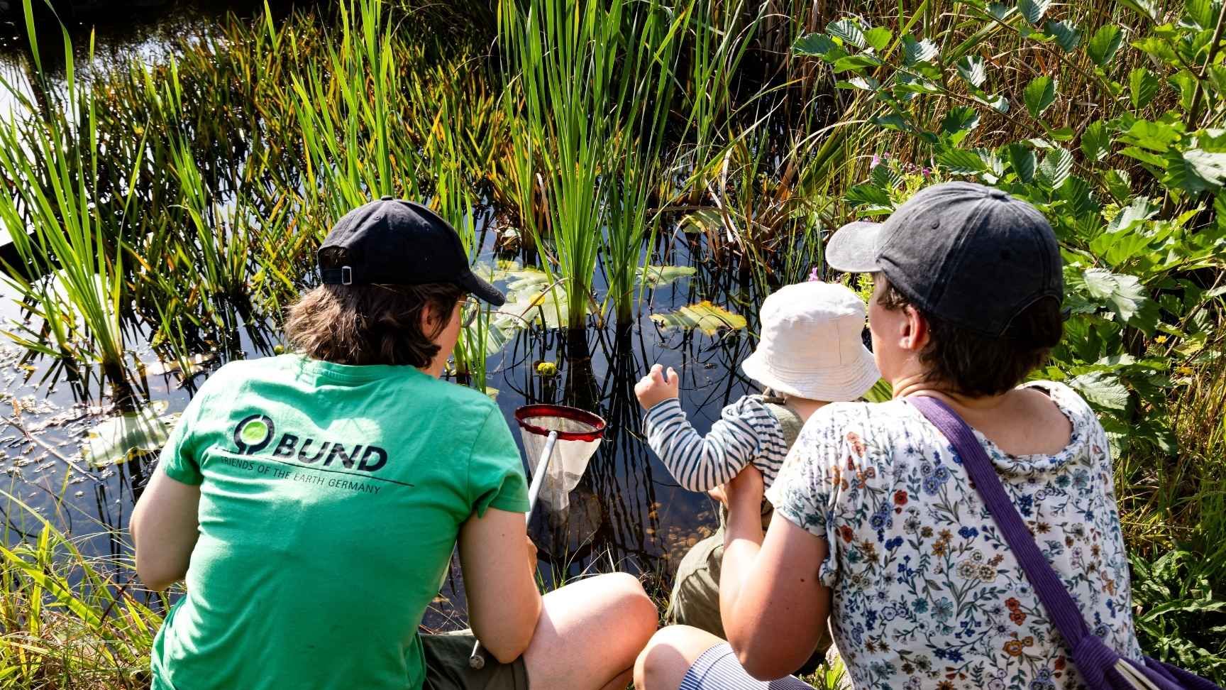 Eine Familie entdeckt den Gartenteich beim BUND