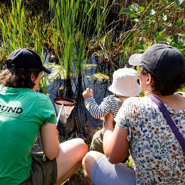 Eine Familie entdeckt den Gartenteich beim BUND