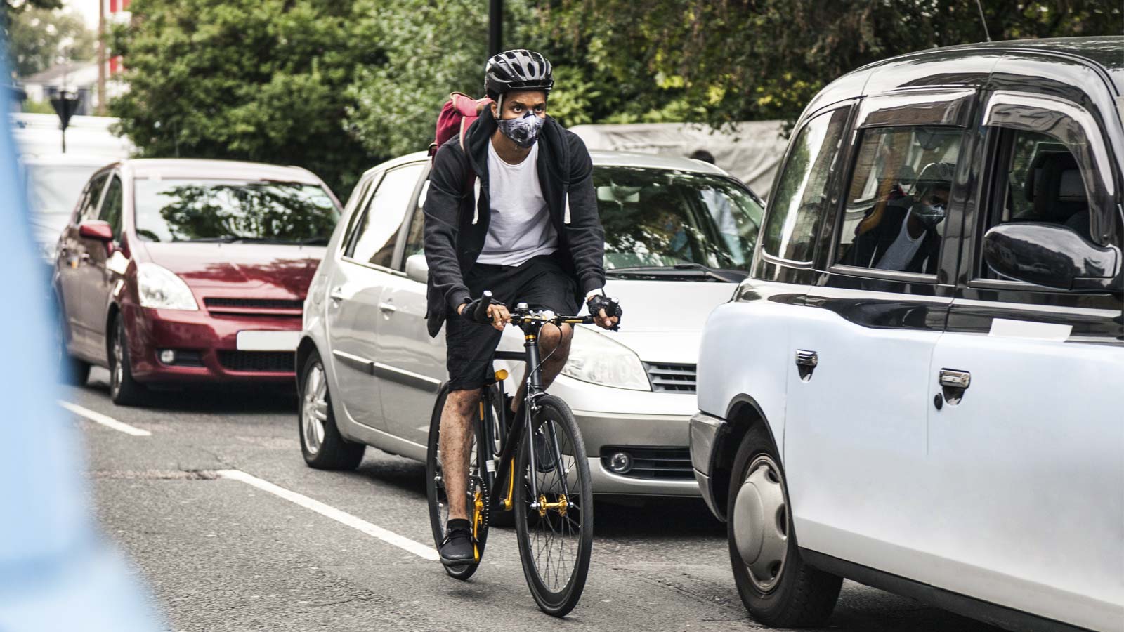 Radfahrer, der sich mit einer Atemmaske zu schützen versucht. Foto: LeoPatrizi / iStock.com